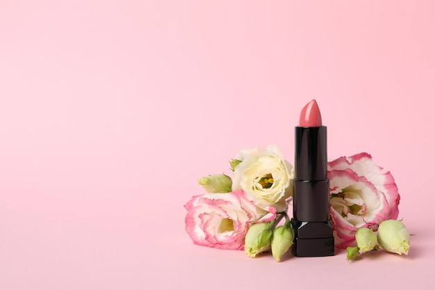 Lipstick and flowers on pink background | Premium Photo