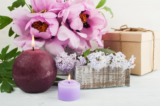 Premium Photo | Lit candles, peonies and lilac flowers