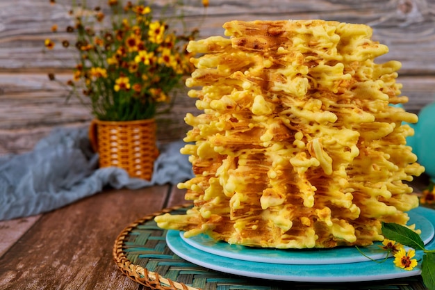 木製の表面に花が付いているリトアニアの伝統的な層状ケーキ プレミアム写真