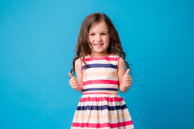 Little baby girl smiling on blue Premium Photo