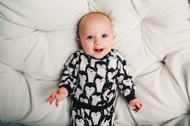 Little baby lying on a round swing and smiling Premium Photo