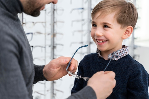 Free Photo | Little boy and father in store trying on glasses