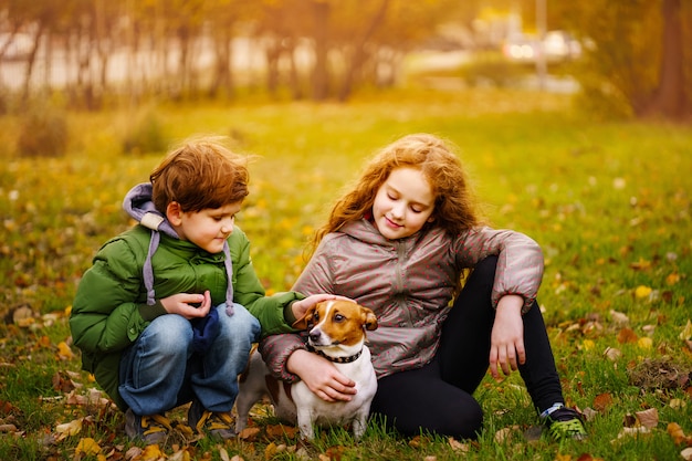 Premium Photo | Little boy and girl with her puppy jack russell in ...