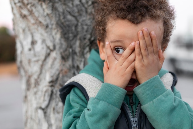 Free Photo | Little boy outdoors covering his face