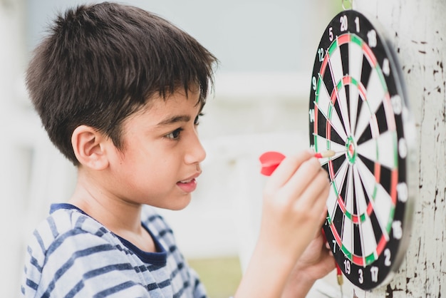 Premium Photo | Little boy playing darts board family outdoor activity