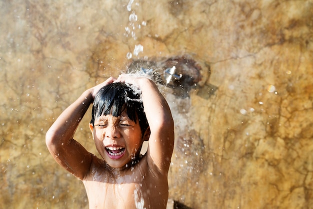 Little boy taking a shower by a swimming pool Free Photo