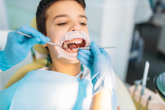 Premium Photo | Little boy with open mouth in a dental cabinet