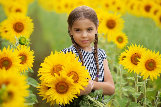 Premium Photo | Little cute girl holding sunflowers