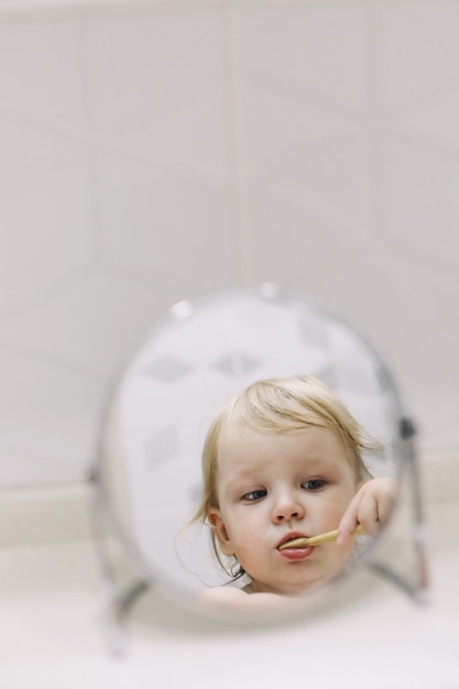 小さな面白い女の子がバスルームで歯を磨く プレミアム写真