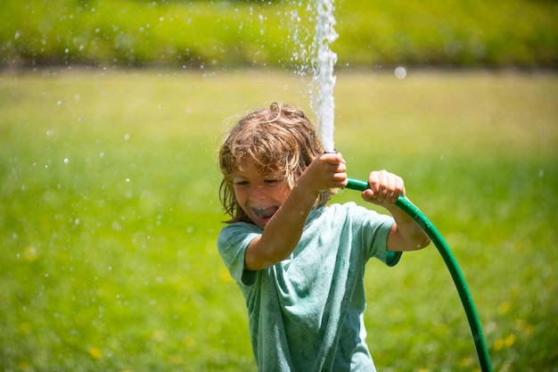 Premium Photo | Little gardener child helping to watering flowers with ...