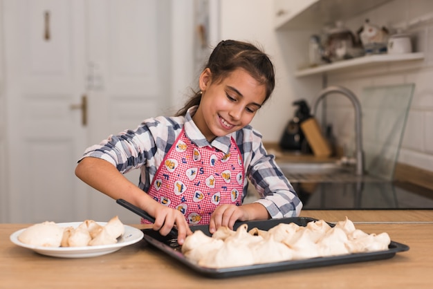 Premium Photo | Little girl cookies out of a baking tray.