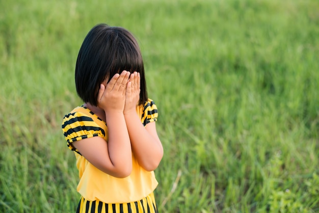 Little girl covering her face Free Photo