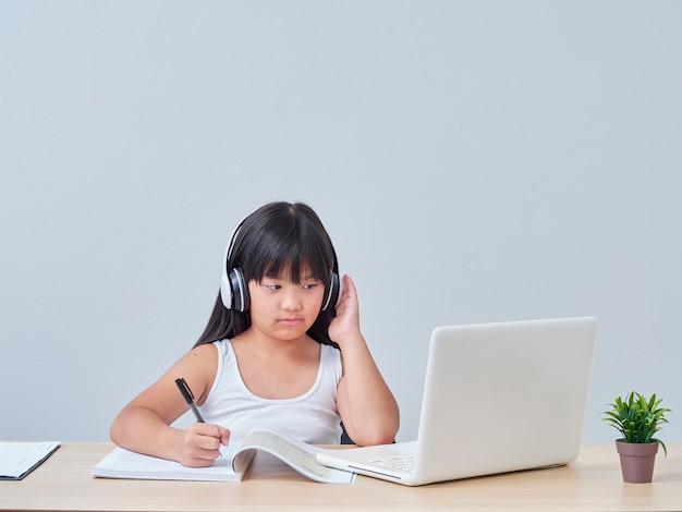 Premium Photo | Little girl doing online class