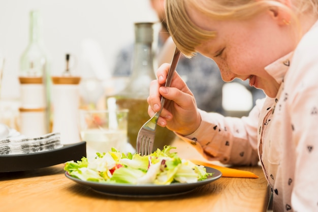 Little girl eating tasty dish  Photo | Free Download