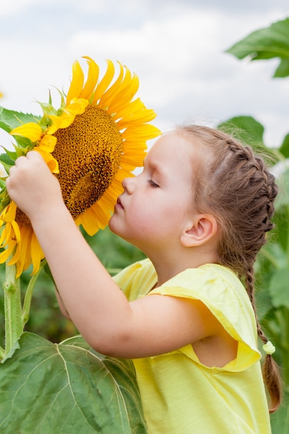 Premium Photo | Little girl on the field with sunflowers. nature