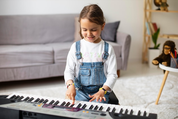 Little girl learning how to play the piano Free Photo