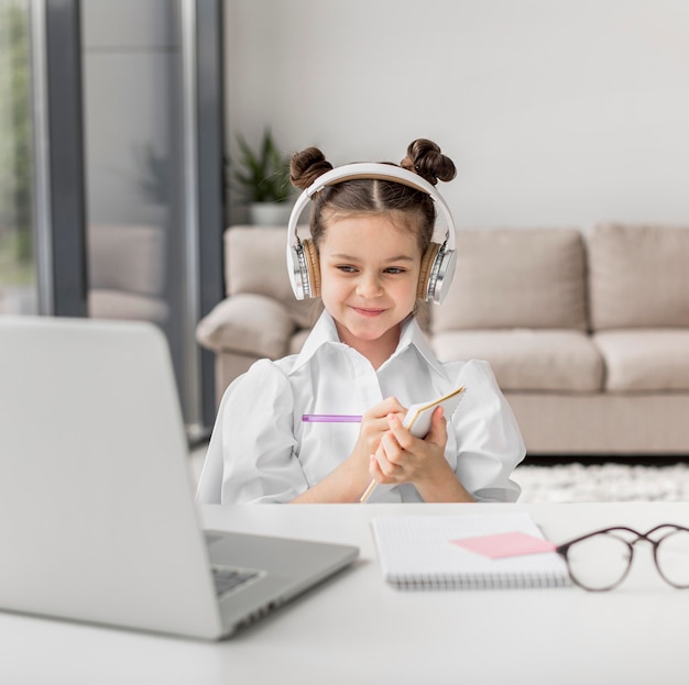 Little girl listening to her teacher through headphones indoors Free Photo