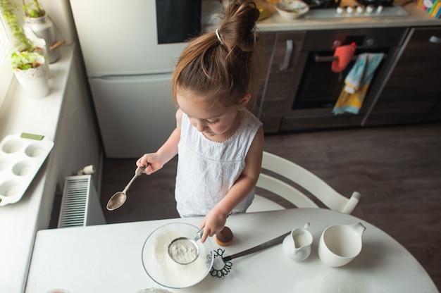 Premium Photo | Little girl makes cookies in the kitchen