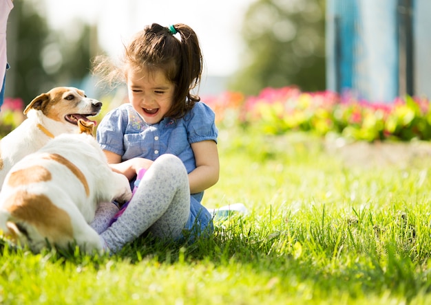 Premium Photo | Little girl playing with dogs