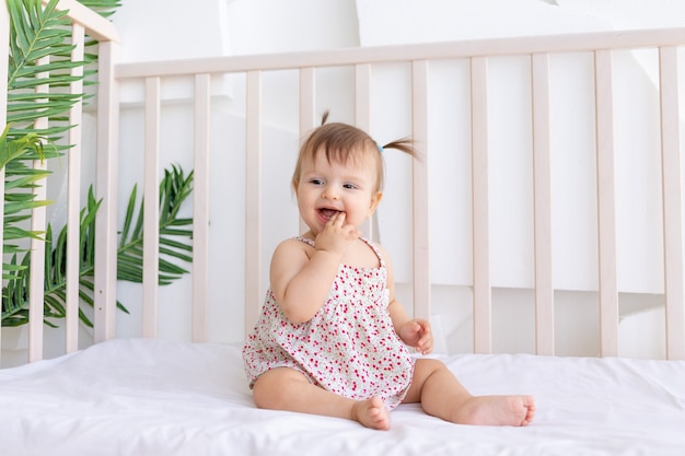 Premium Photo | Little girl sitting in a crib at home