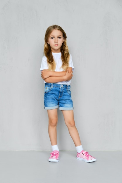 Premium Photo | Little girl in white t-shirt, jeans shorts and pink ...