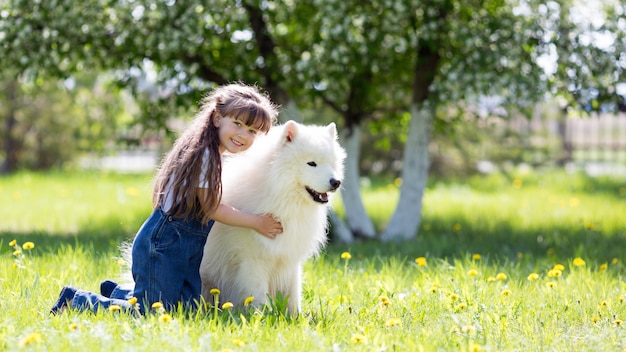 公園で大きな白い犬と少女 プレミアム写真