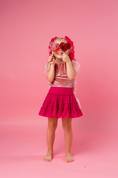 Premium Photo | Little girl with braids of pink kanekalon holds a heart ...