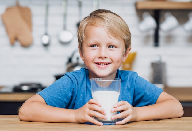 Little kid holding a glass of milk | Free Photo