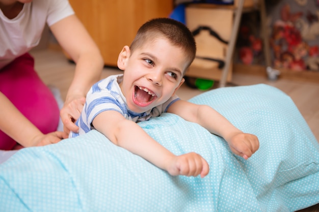 Little kid with cerebral palsy has musculoskeletal therapy by doing exercises Premium Photo