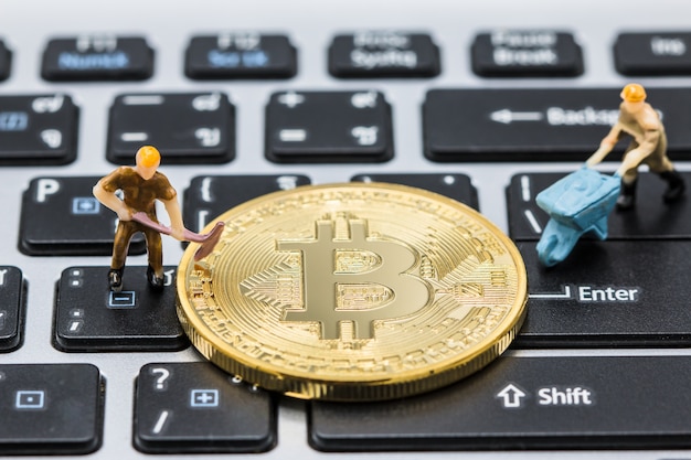 A little miner is digging for bitcoin with thai keyboard or laptop. Premium Photo