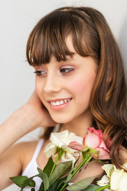 Premium Photo | Little pretty girl in pink holds the bouquet of roses ...