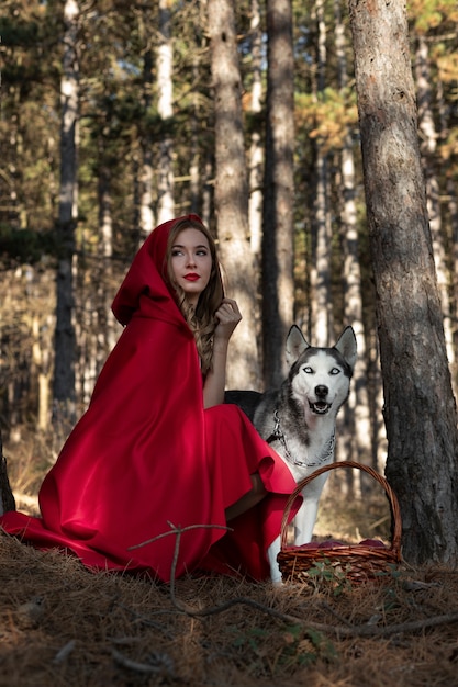 Premium Photo | Little red riding hood with adorable husky