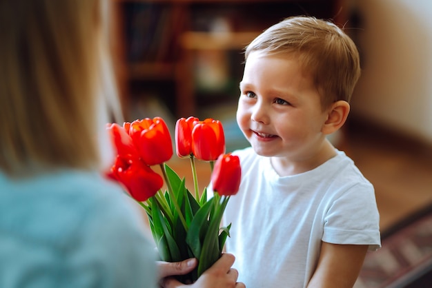 Premium Photo Little Son Congratulates Mother And Gives A Bouquet Of