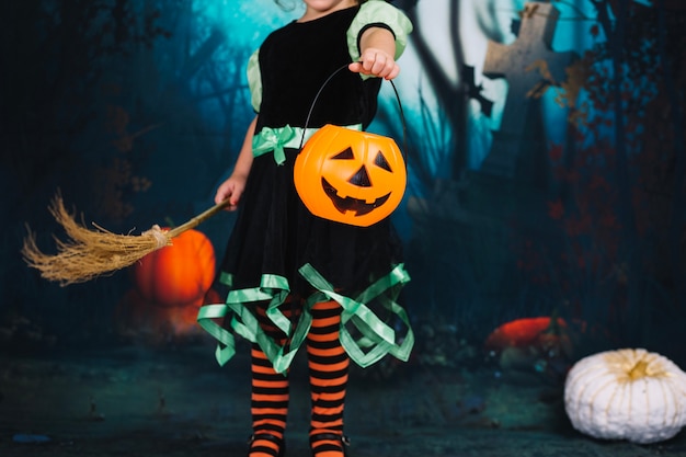 Free Photo | Little witch holding broom and basket
