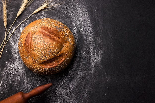 Download Premium Photo Loaf Of Round White Bread With Sesame Seeds And Poppy Seeds On A Black Space Copy Space