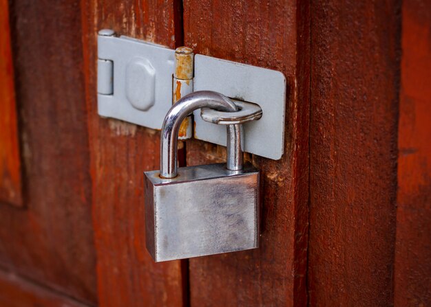 Premium Photo | Locked padlock with chain at brown wooden door