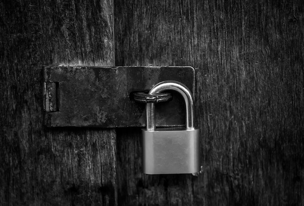 Premium Photo | Locked padlock with chain at gray wooden door. black