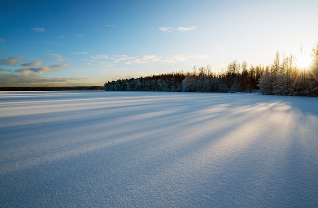 Premium Photo | Long shadows on the snow on the frozen lake.