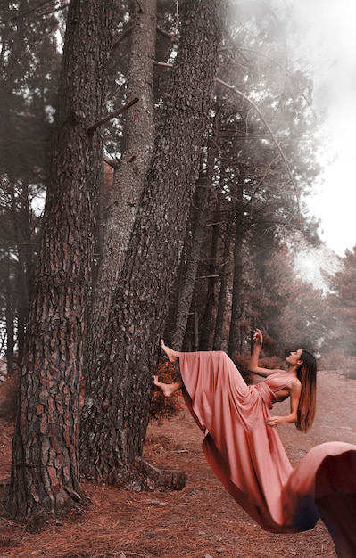 Free Photo | Long shot woman in dress climbing a tree