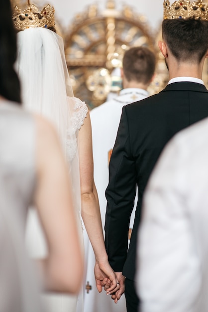 Look from behind at wedding couple standing in the crowns during the ...