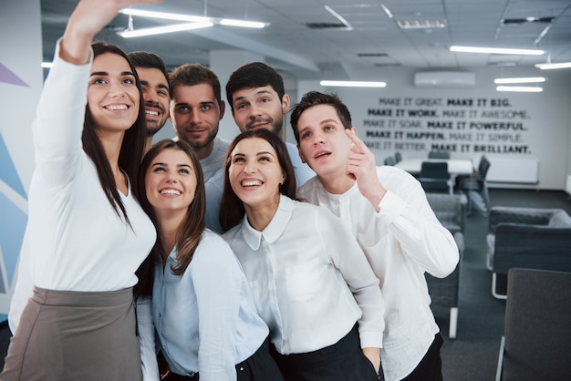 Premium Photo Looking Into The Camera Young Team Making Selfie In Classical Clothes In The Modern Good Lighted Office