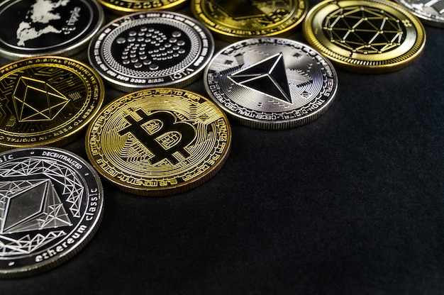 A lot of cryptocurrency coins lie on a dark surface Photo ...