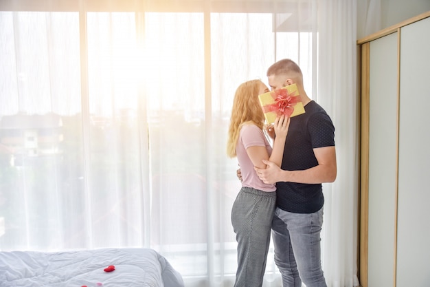 Premium Photo | Love couple giving gift box in bedroom happiness in