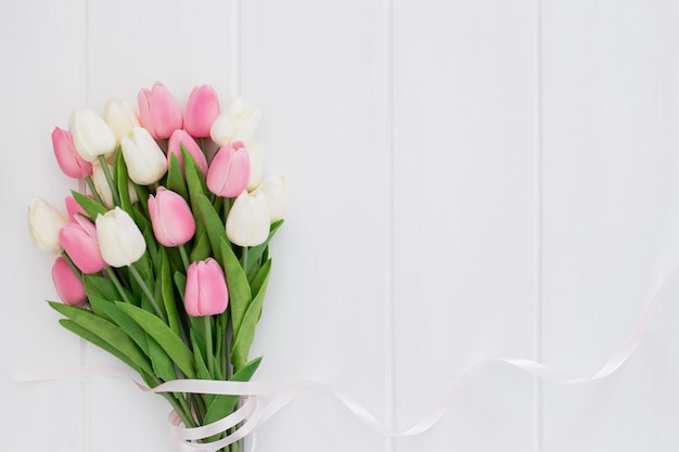 白い木製の背景にピンクと白のチューリップの素敵な花束 無料の写真