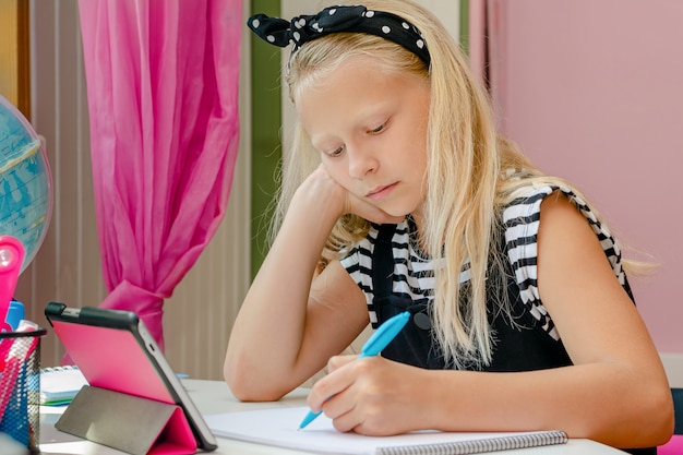 素敵な白人の左利きの学校の女の子は 宿題をしながら退屈しました 教育のコンセプトです プレミアム写真
