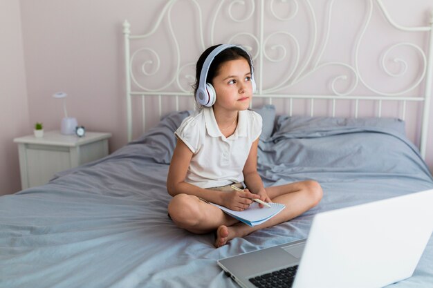 Lovely little girl using her laptop Free Photo