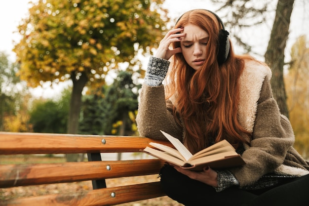 Premium Photo | Lovely redheaded young girl listening to music with ...