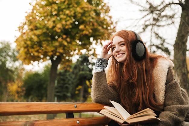 Premium Photo | Lovely redheaded young girl listening to music with ...