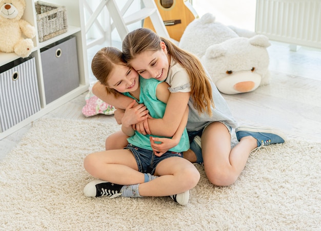 Premium Photo Lovely Sisters Cuddling In Playroom