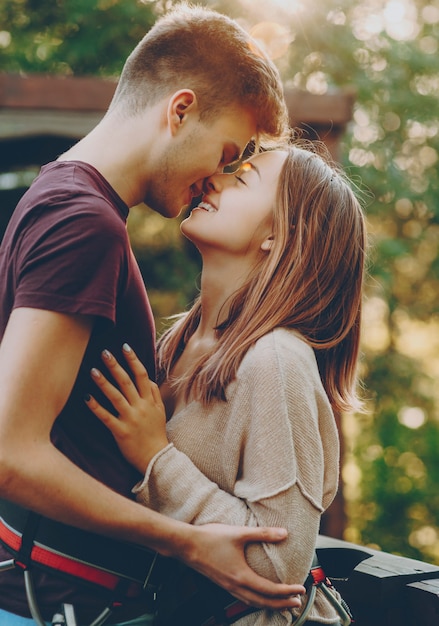 ロープスライドプラットフォームで夕日にキスした後 抱きしめて笑っている素敵な若い婚約中のカップル プレミアム写真
